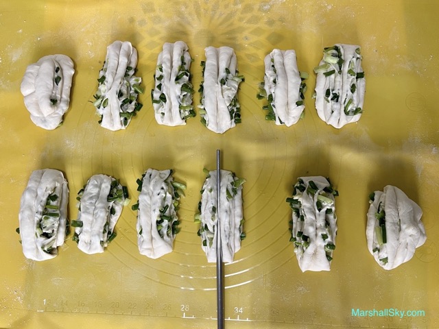 Marshall 蔥花捲饅頭-取2等份麵糰，上下合疊，用一根筷子從上壓下擠花。
