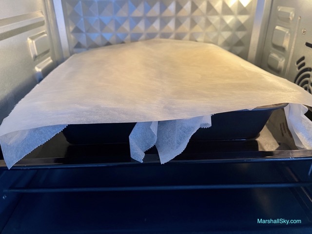 Marshall 輕乳酪蛋糕-烤盤上蓋上烘焙紙，繼續水浴烘烤。